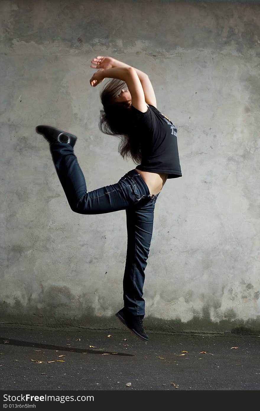 Young girl jumping against the wall. Young girl jumping against the wall.