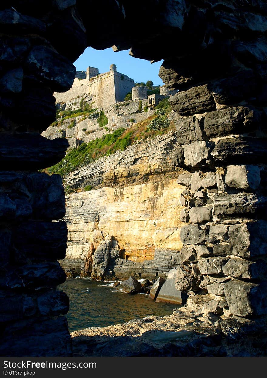 A suggestivbe shot of Doria castle in Porto Venere viewes by an ancient open window. A suggestivbe shot of Doria castle in Porto Venere viewes by an ancient open window