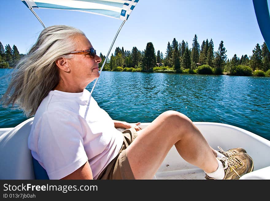 Senior woman in paddle boat on pond. Senior woman in paddle boat on pond