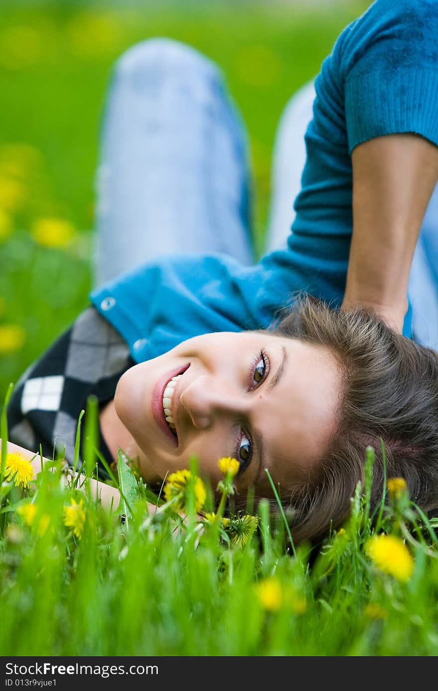 Nice girl is smiling on the field of dandelions. Nice girl is smiling on the field of dandelions