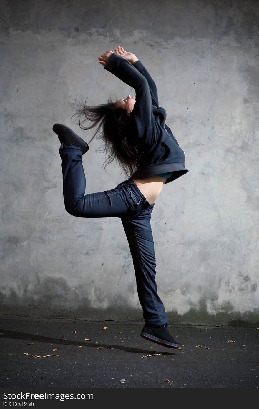 Young girl jumping against the wall. Young girl jumping against the wall.