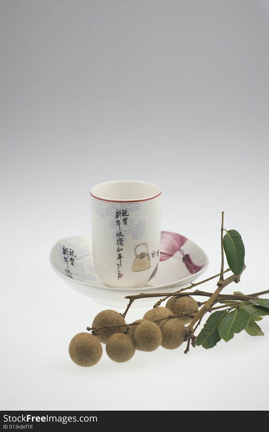 The chinese teacup with traditional Chinese painting and longan