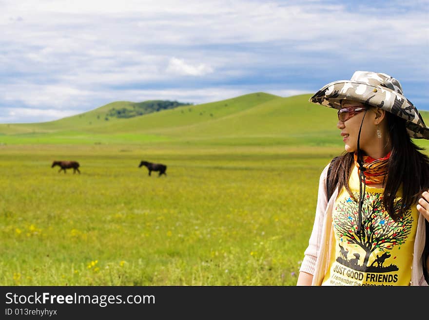 Happy girl on meadow against the blue sky and clouds