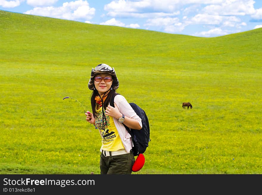 Happy girl on meadow against the blue sky and clouds