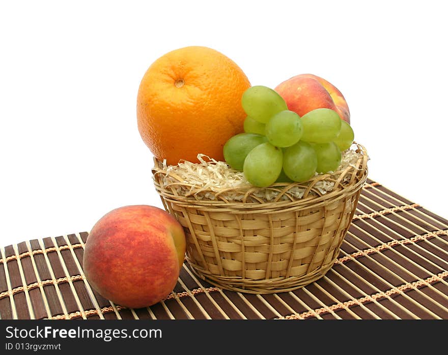 Peaches and orange in a yellow basket. Peaches and orange in a yellow basket