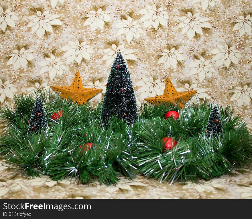 Lovely Christmas scene with a gold and white poinsettia background, green and silver tinsel, christmas trees, red balls, and gold/brass stars.