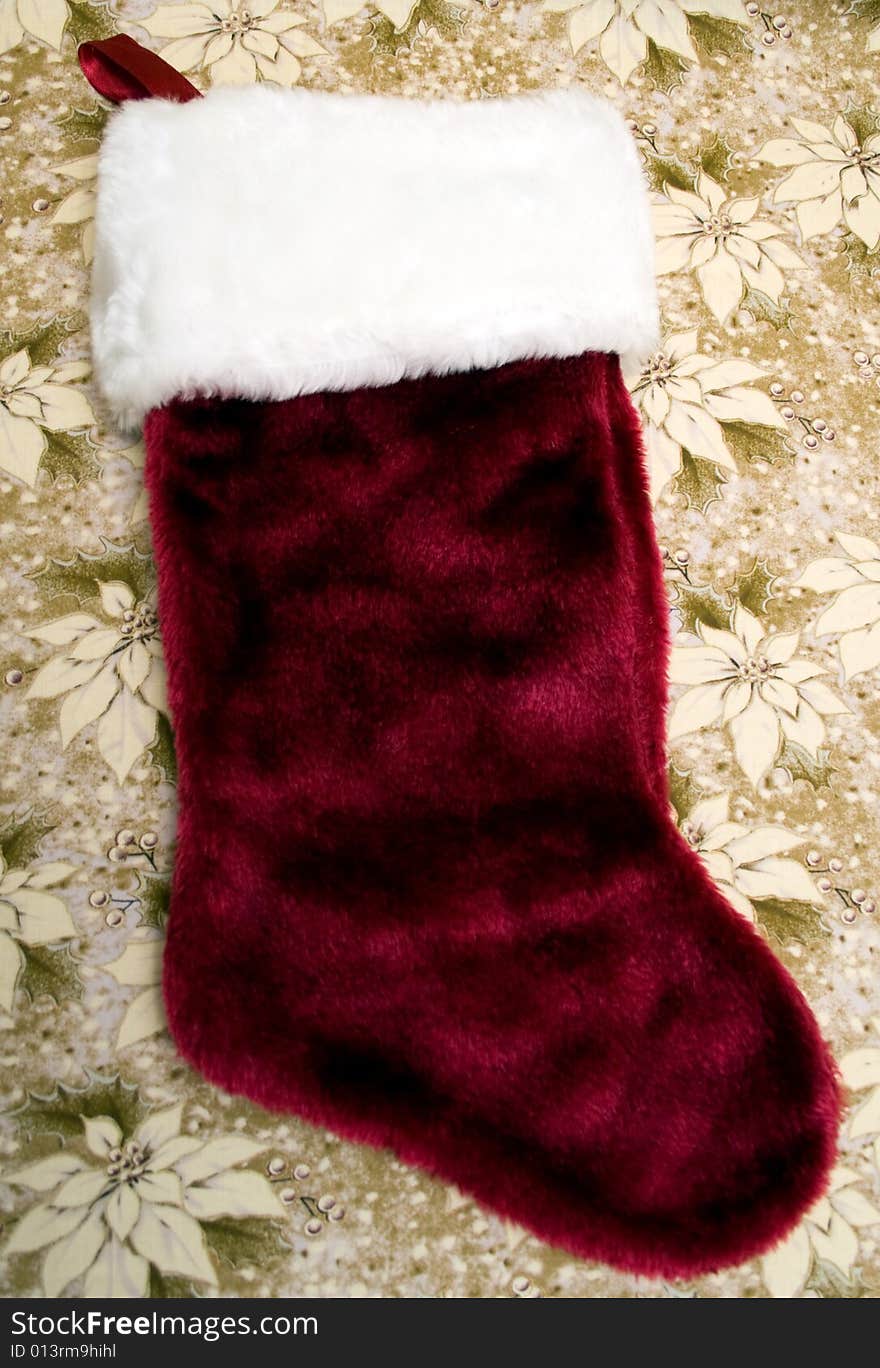 Dark red stocking on a white/gold poinsettia background.