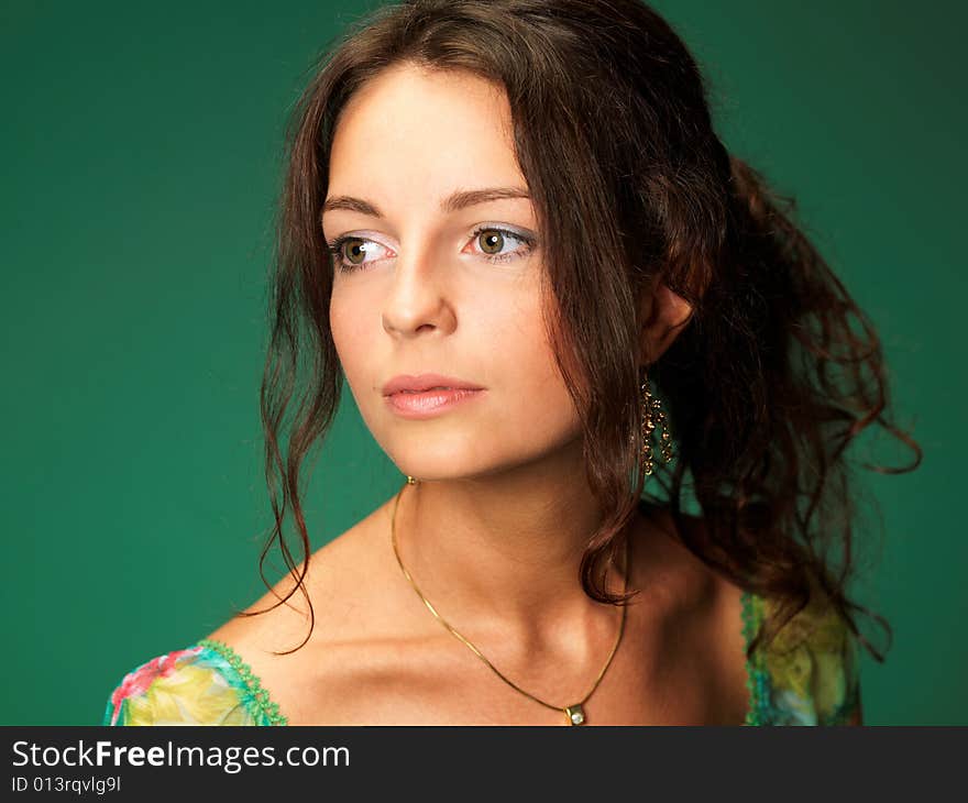 The beautiful girl on a green background in a green dress