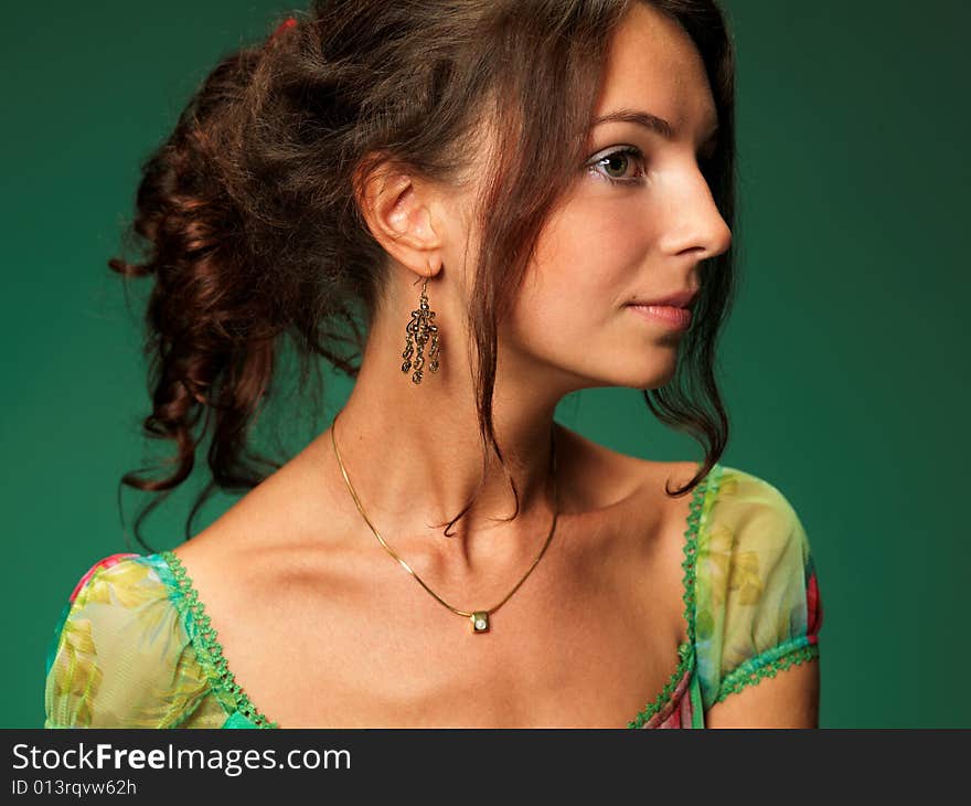 The beautiful girl on a green background in a green dress