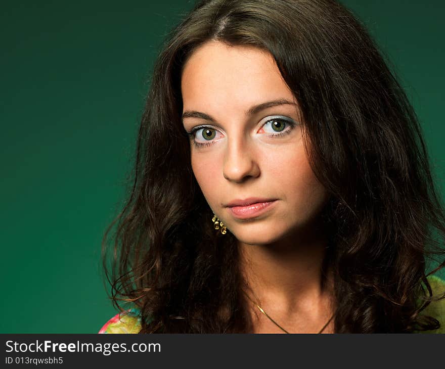 The beautiful girl on a green background in a green dress