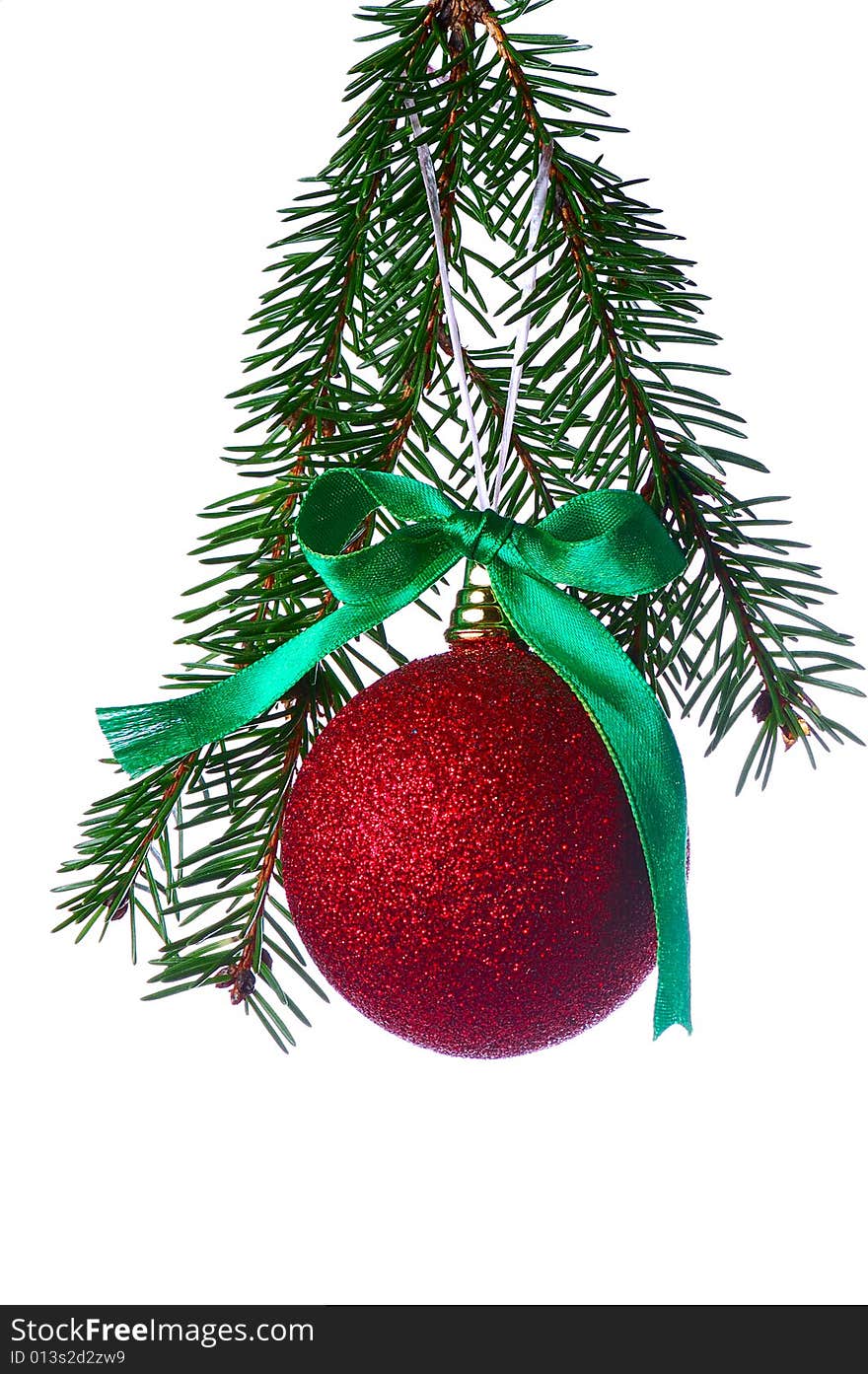 Red ball on fir branch with ribbons and bow isolated on white