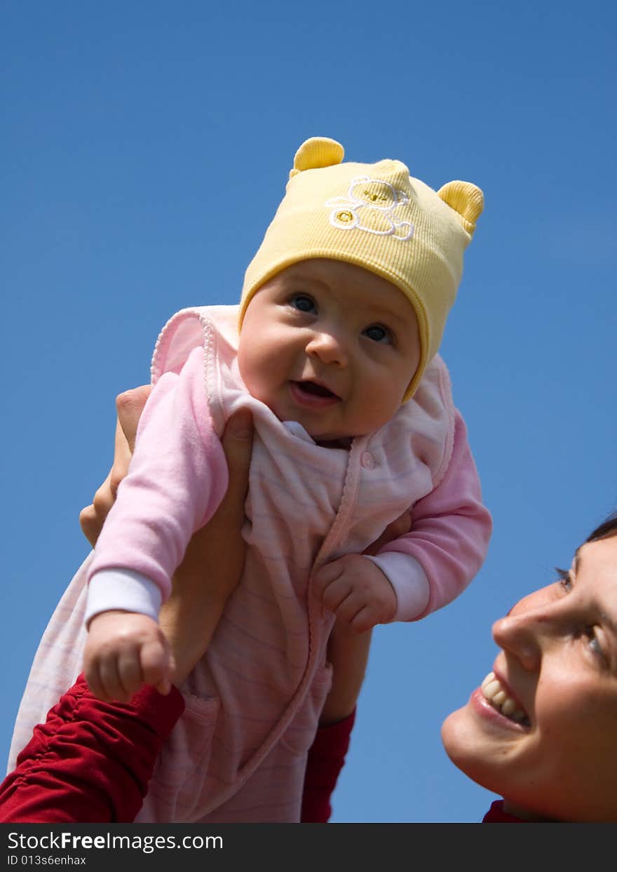 Baby with mom on blue sky background