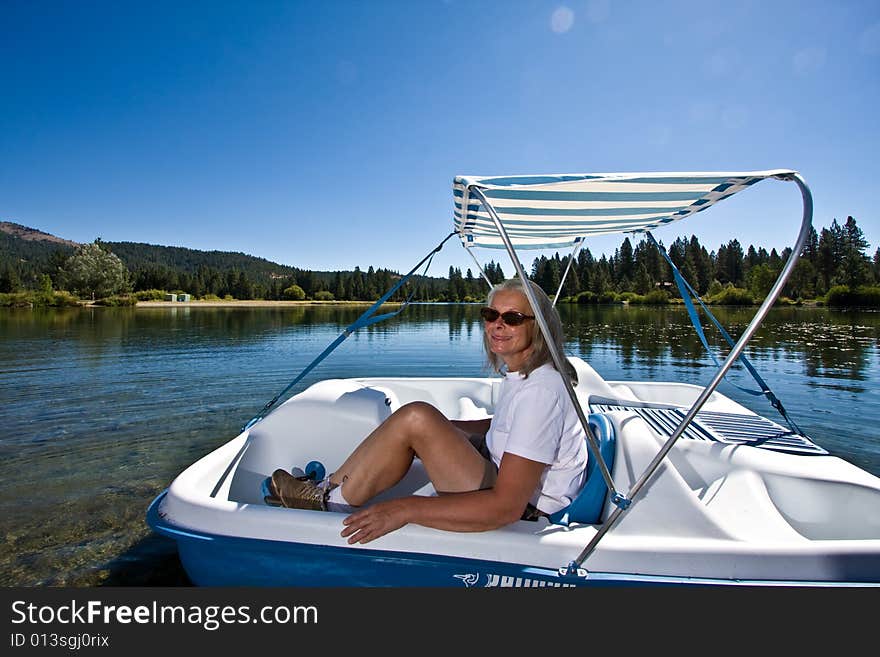 Senior woman in paddle boat on pond. Senior woman in paddle boat on pond