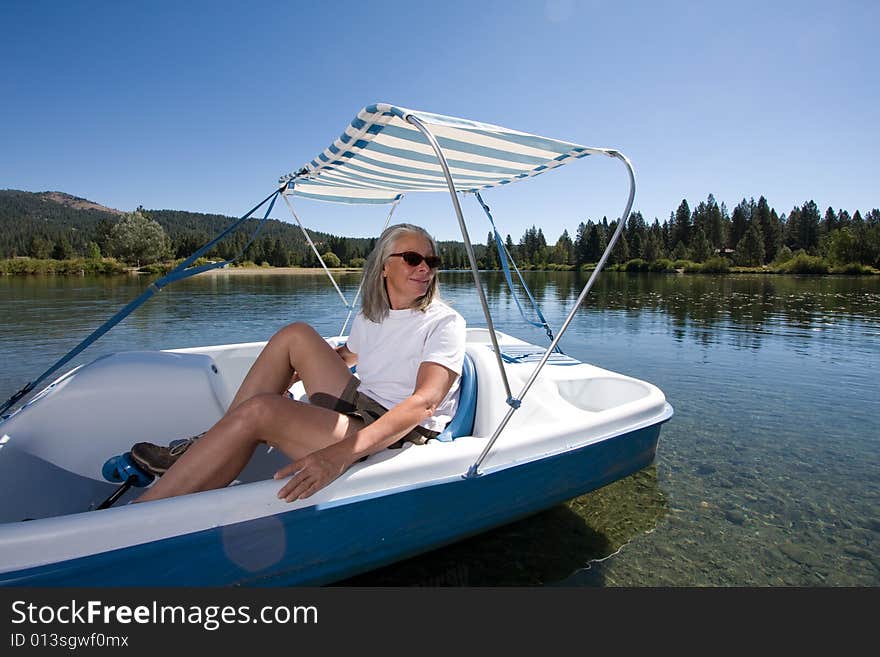 Senior woman in paddle boat on pond. Senior woman in paddle boat on pond