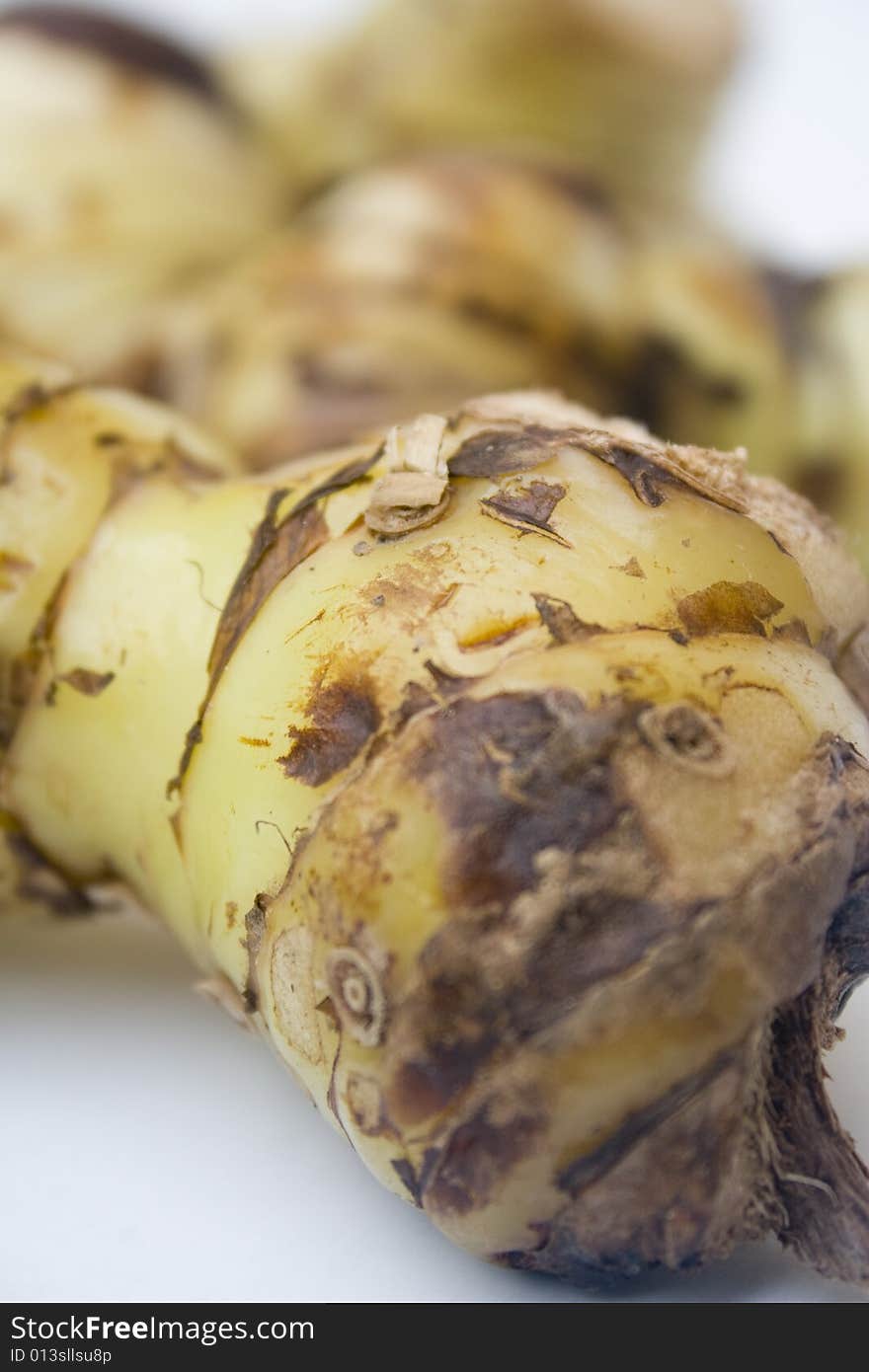 A stack of galangal root isolated against a white background