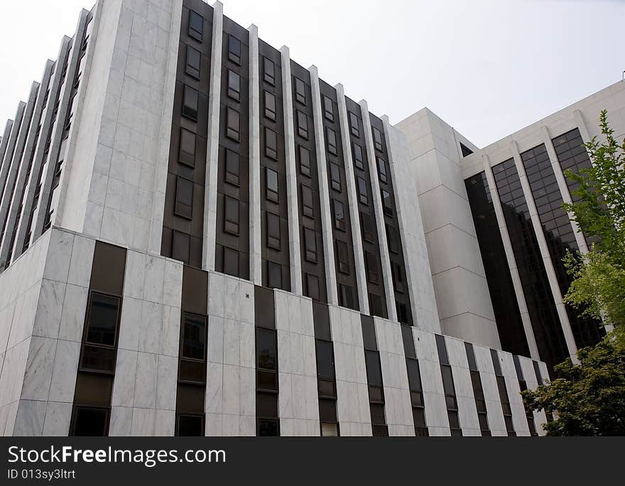 A modern white marble courthouse with black windows