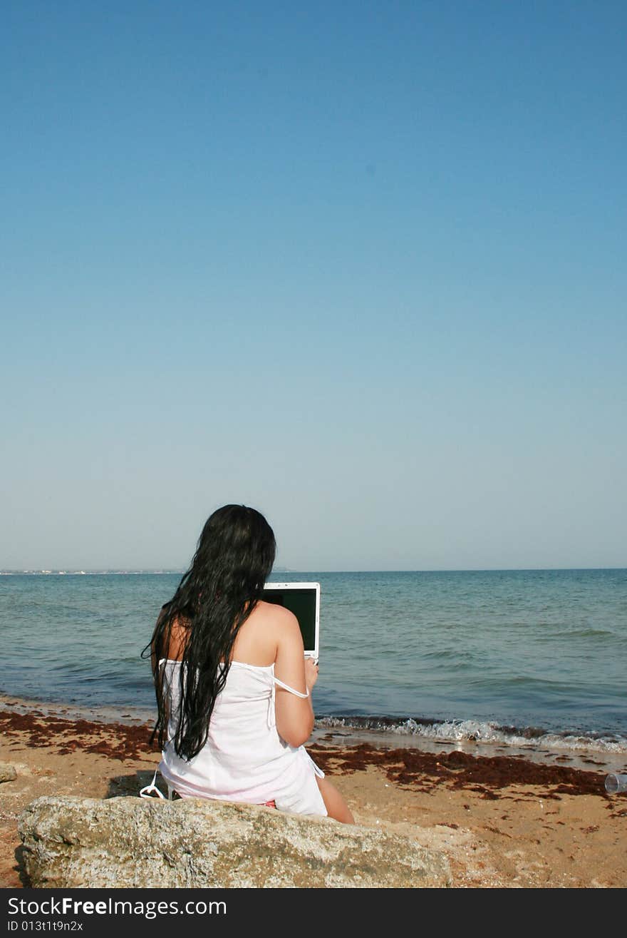 Girl on a beach with a notebook