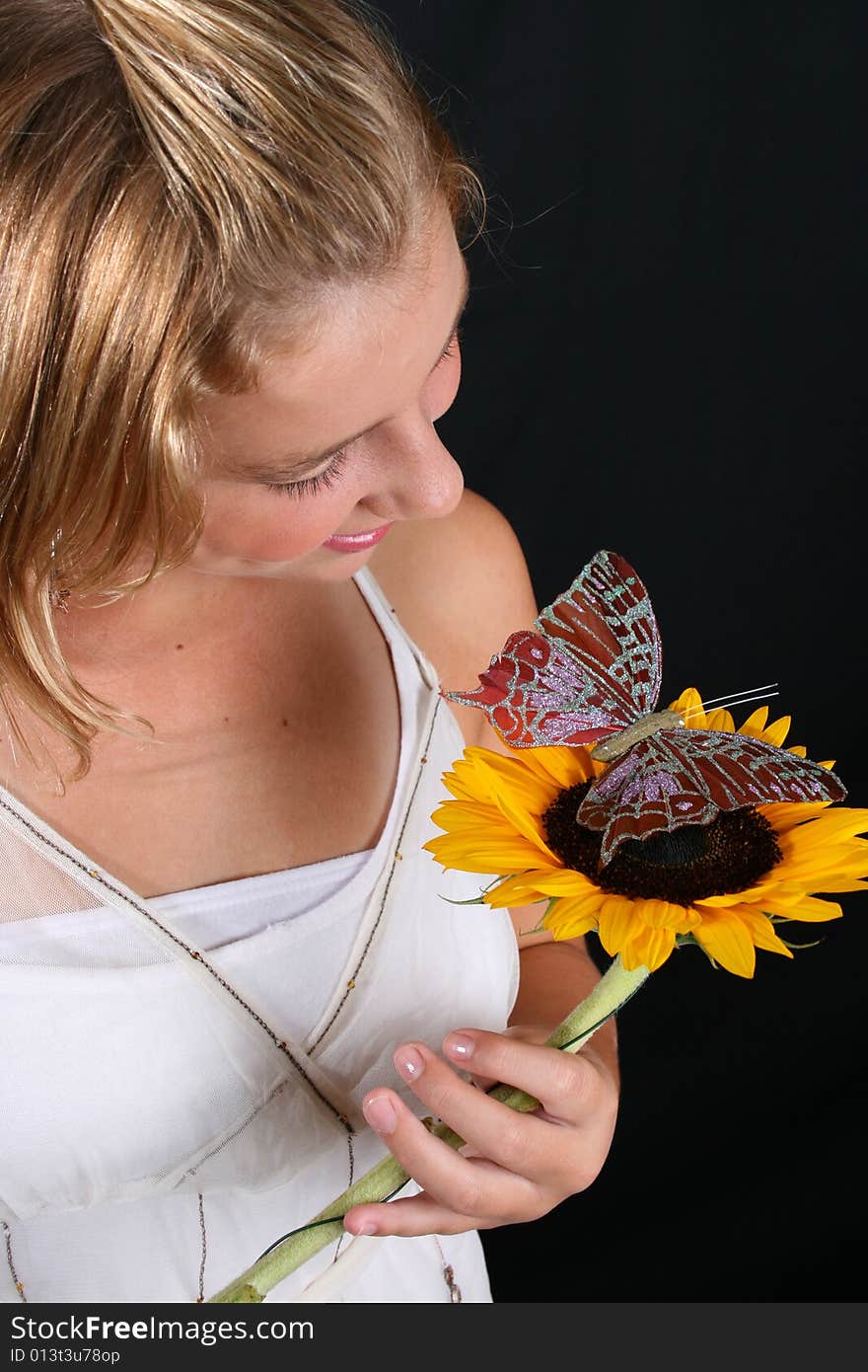 Teenage female model holding a sunflower with a butterfly. Teenage female model holding a sunflower with a butterfly