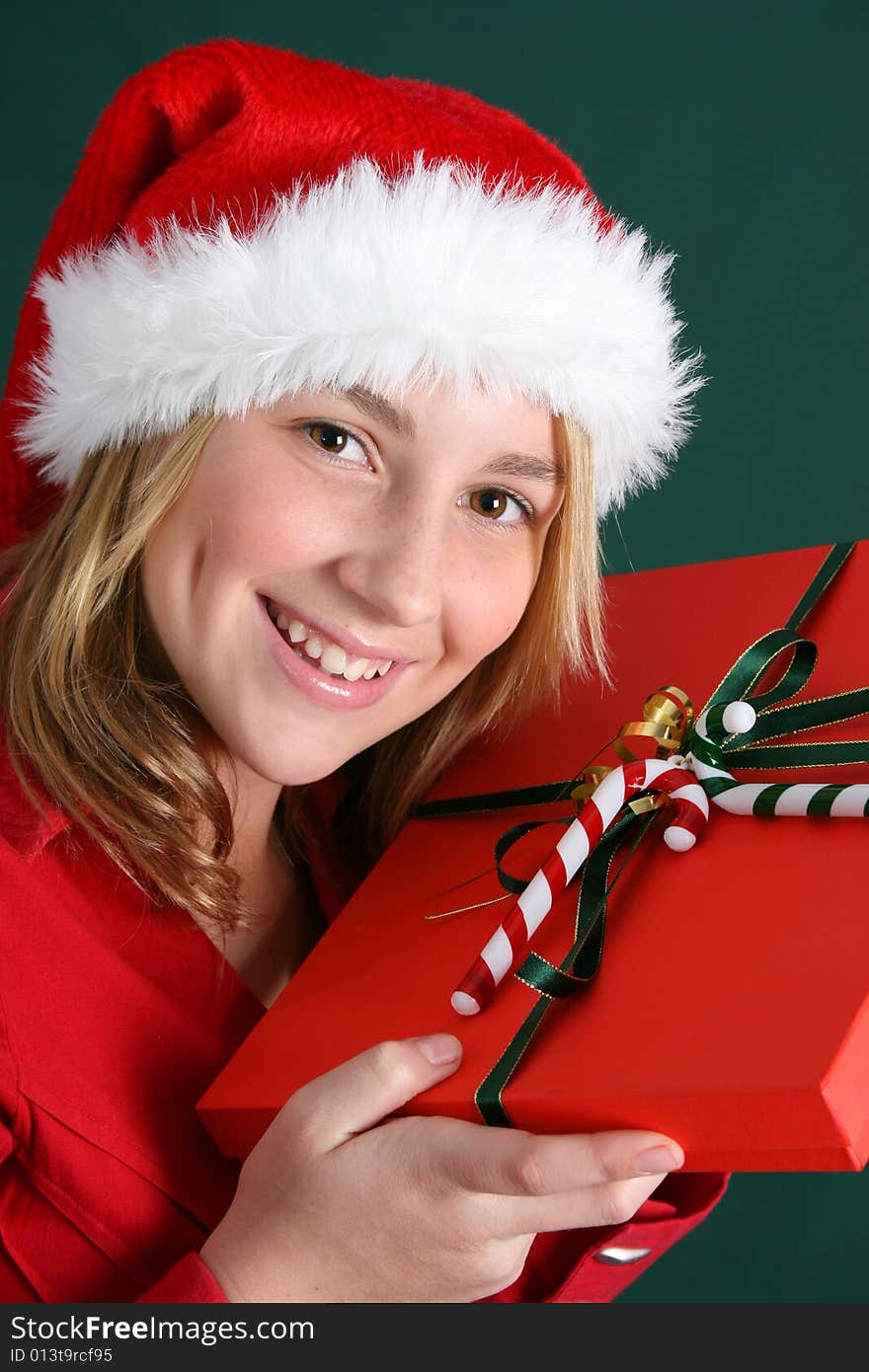 Teenager wearing a christmas hat, holding a present. Teenager wearing a christmas hat, holding a present