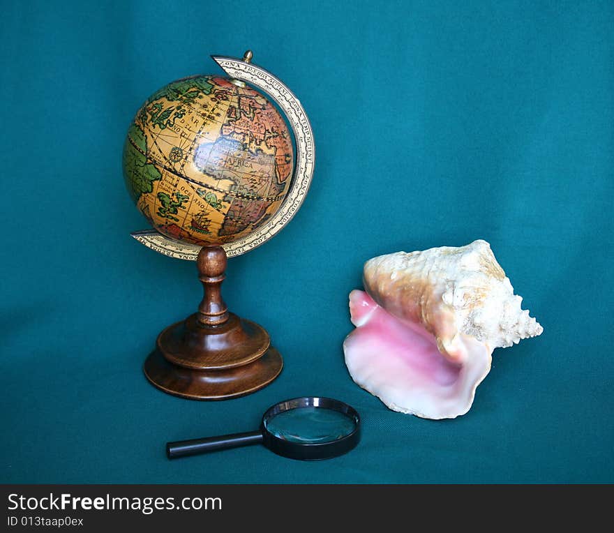 Still life with globe, shell and magnifying glass