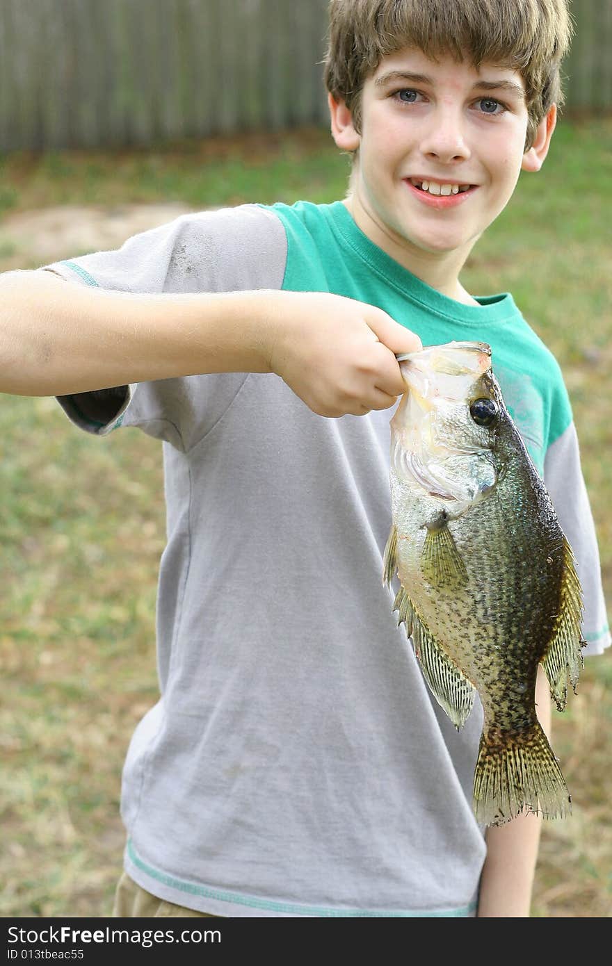 Shot of a young boy holding fish he caught