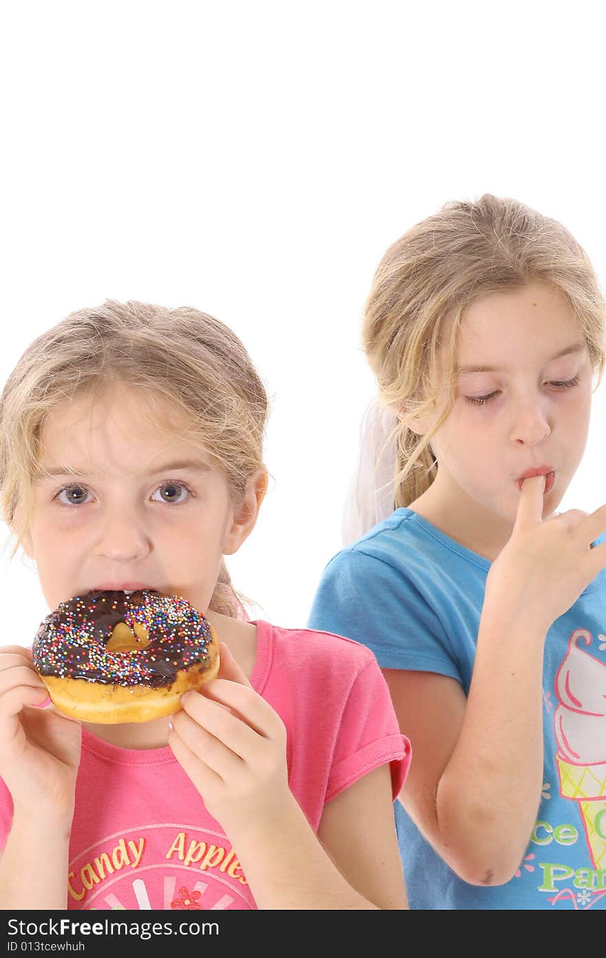 Twin sisters eating a doughnut vertical