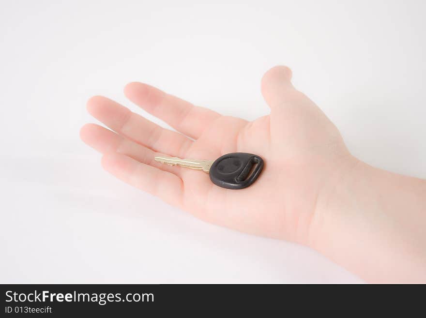 A woman's hand holding a key against a white backgound