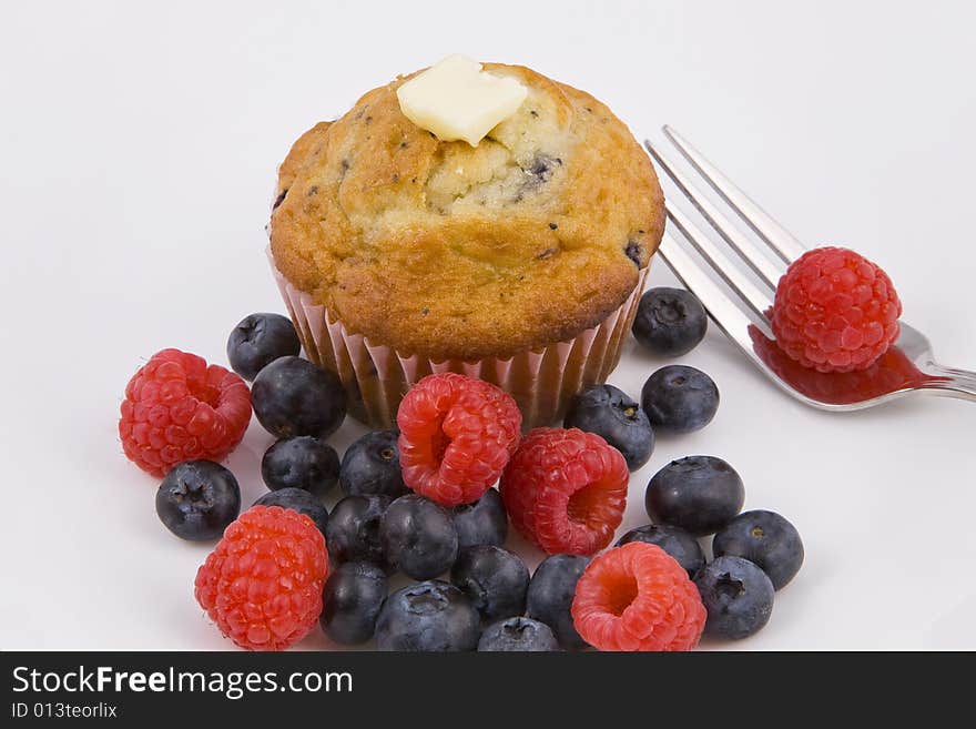 Hot muffins & fresh berries on white plate with fork. Hot muffins & fresh berries on white plate with fork