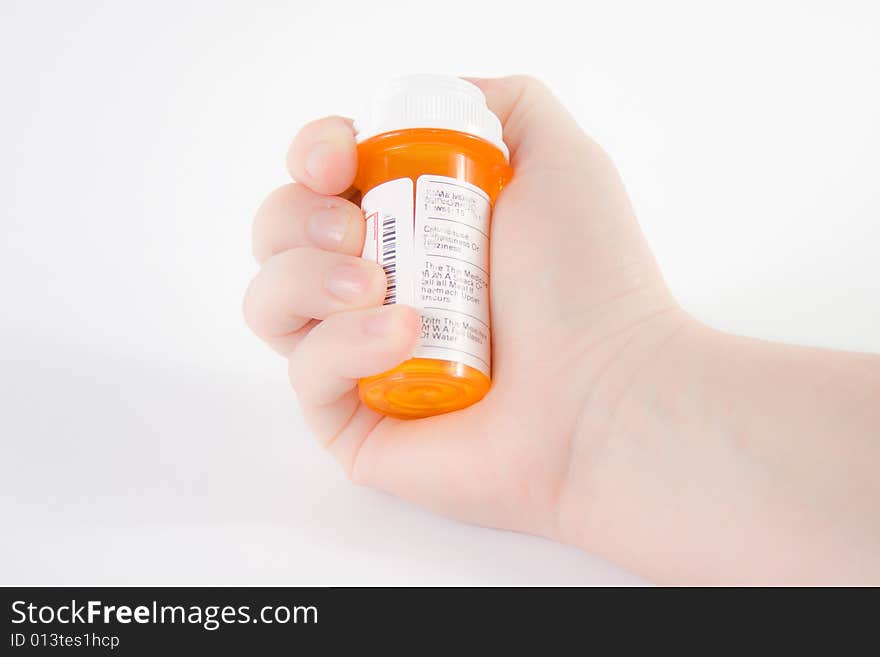 Hand holding a bottle of medicine against a white background. Hand holding a bottle of medicine against a white background