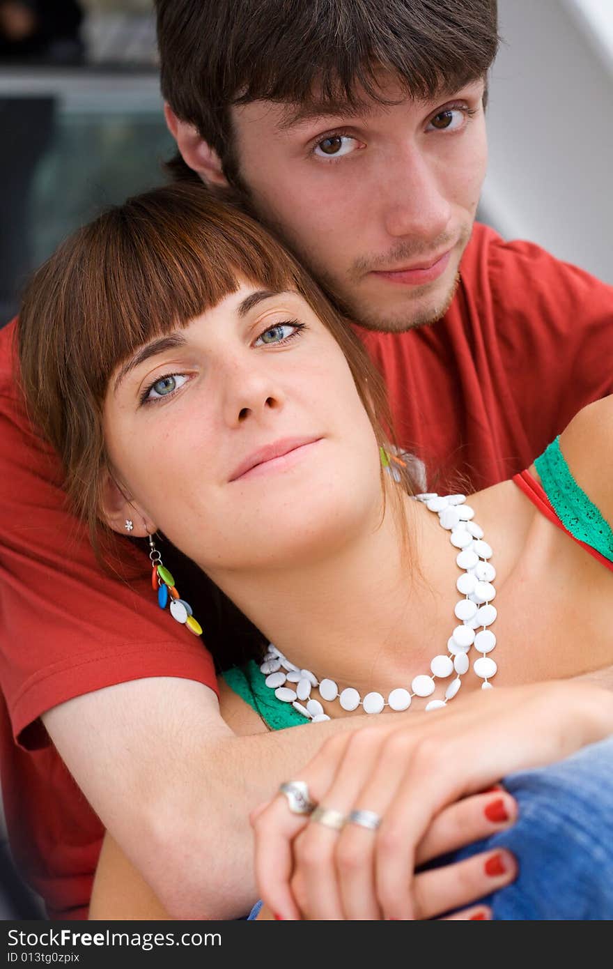 Young relaxed teenagers sit together and look towards. Young relaxed teenagers sit together and look towards