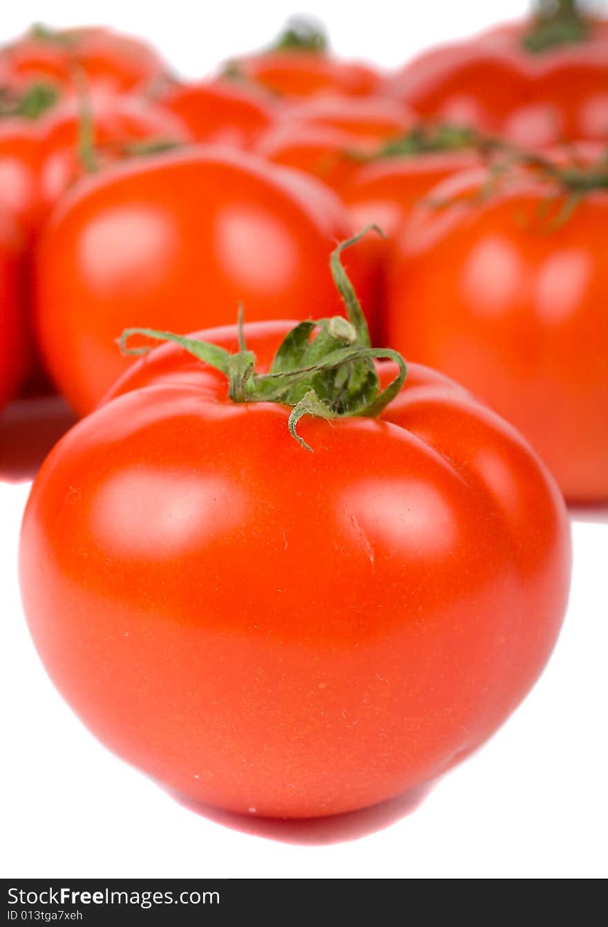 Close-up ripe tomato on tomatoes background, isolated on white