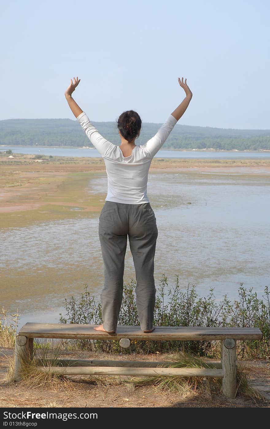 Happy woman making stretching movements sitting on a park