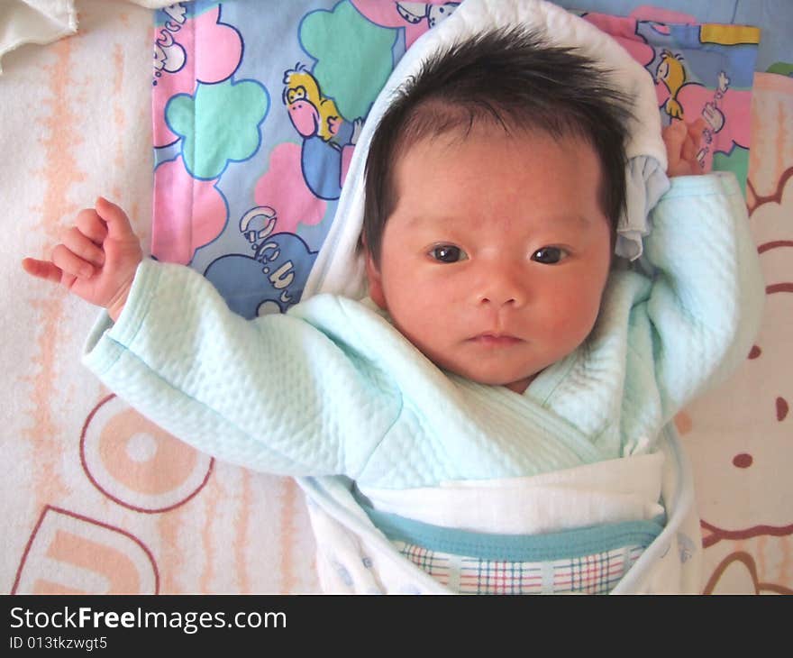 Lovely Baby in blue on a bed. Lovely Baby in blue on a bed