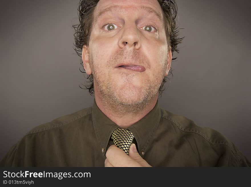 Man Concentrating Fixing Tie on a Grey Background