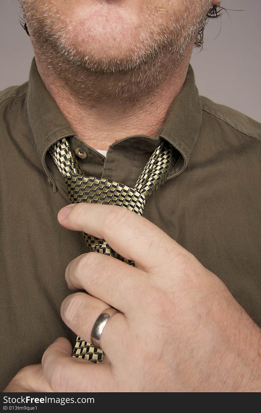 Man Fixing Tie Against Grey Background