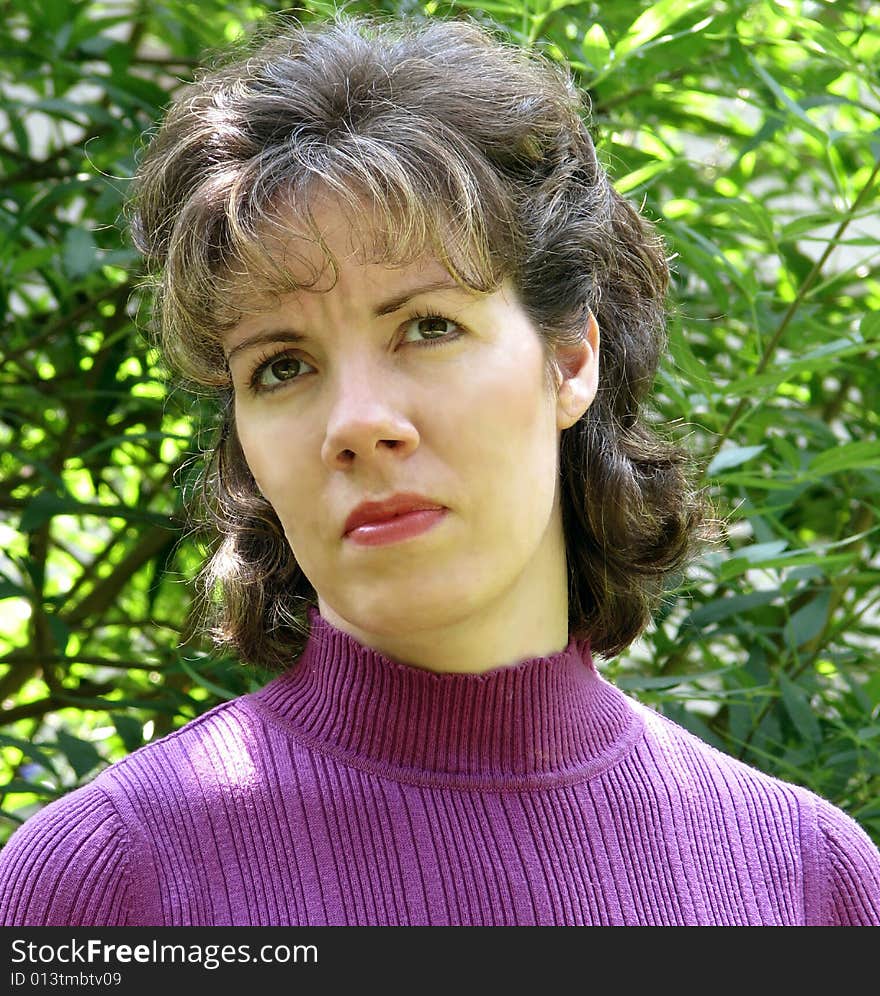 Puzzled young woman looks upward. Purple sweater, medium length brown hair with blond streaks. Puzzled young woman looks upward. Purple sweater, medium length brown hair with blond streaks.