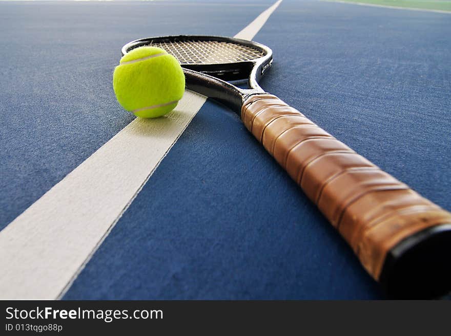 Tennis ball and racquet on a court line