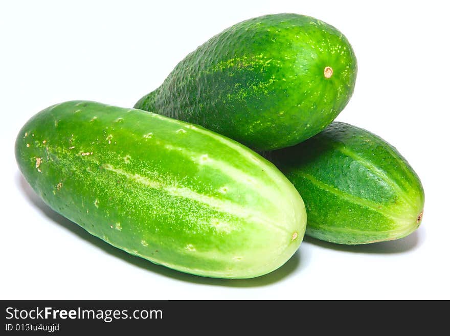 Three green cucumbers isolated over white