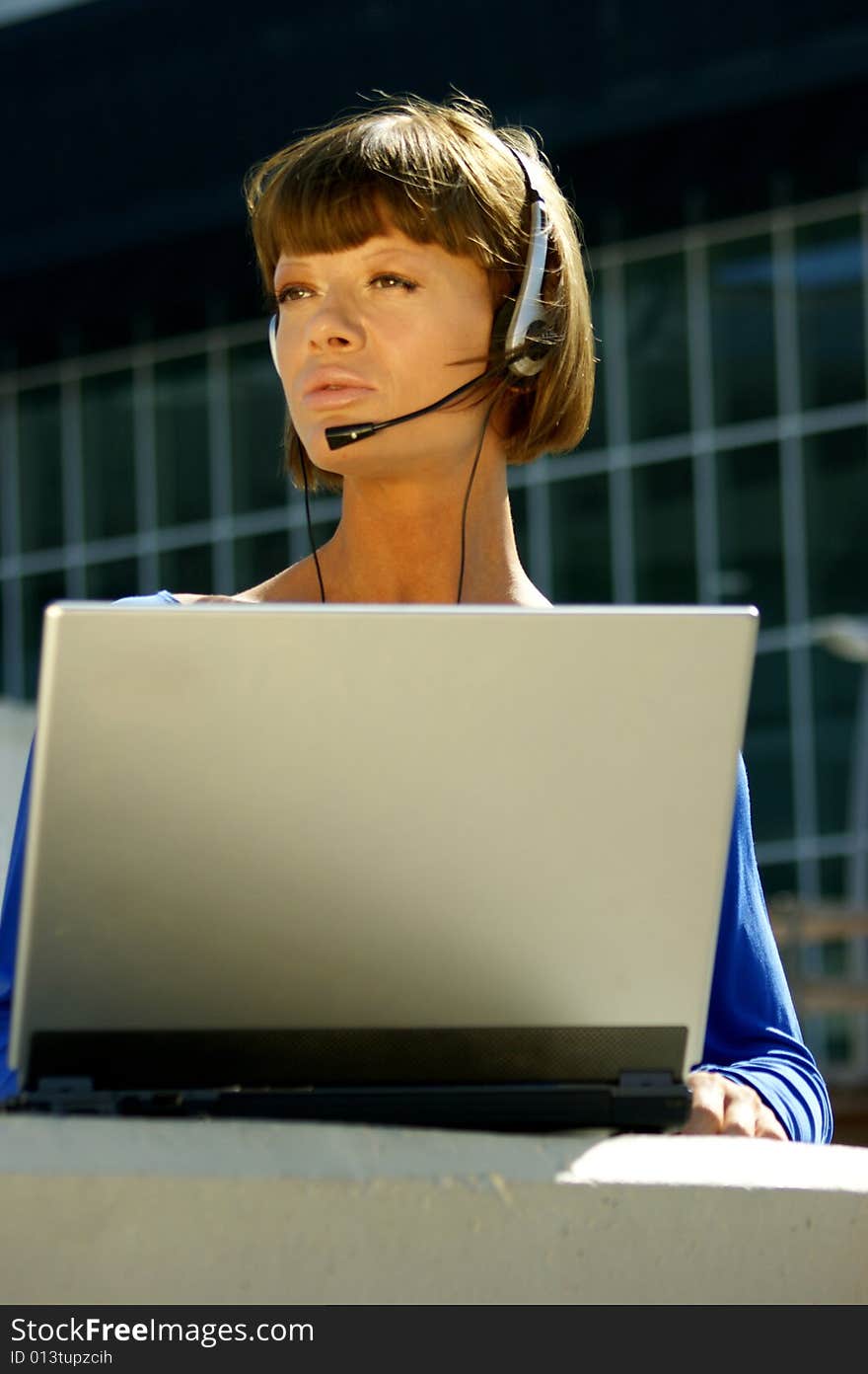 Young woman with a laptop and headset