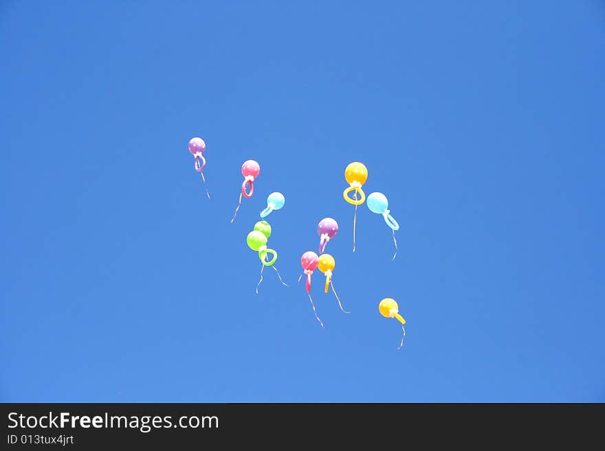 Colorful balloons flying in the blue sky.