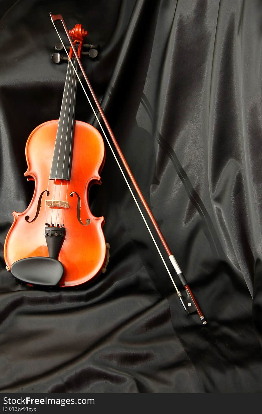 Violin and bow on black silk