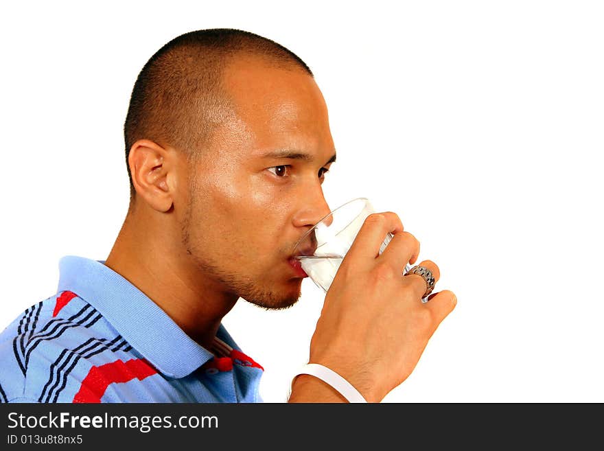 A young man drinking water out of a glass. Isolated over white.