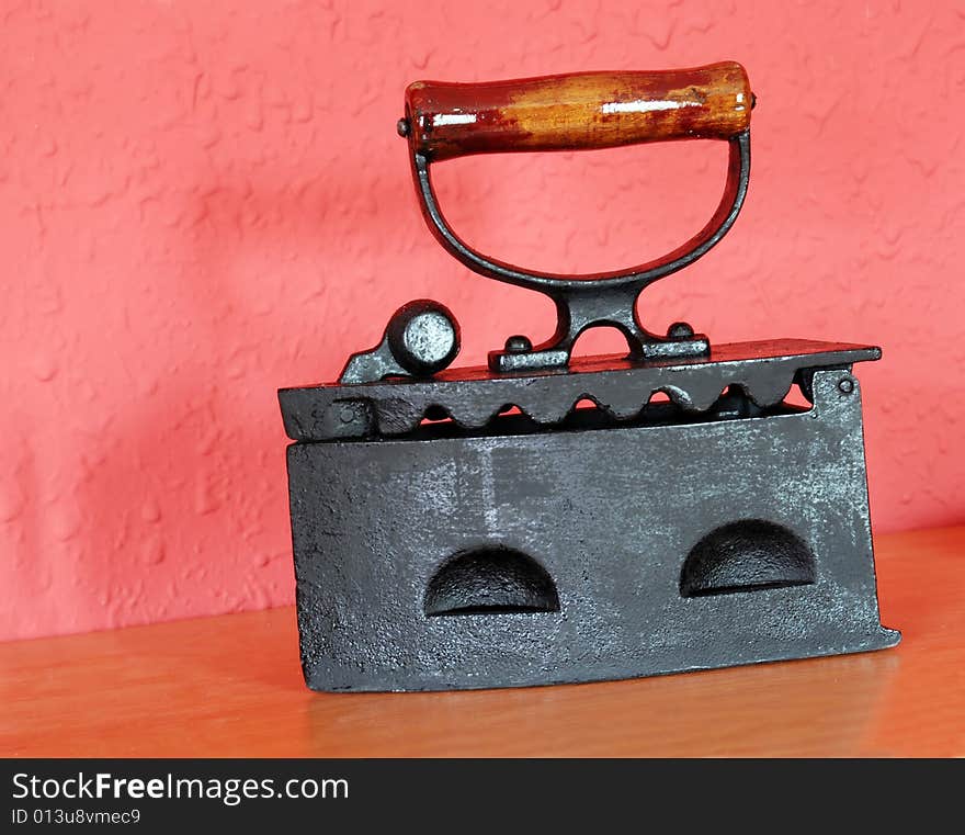 Old black massive iron over red wall. Old black massive iron over red wall