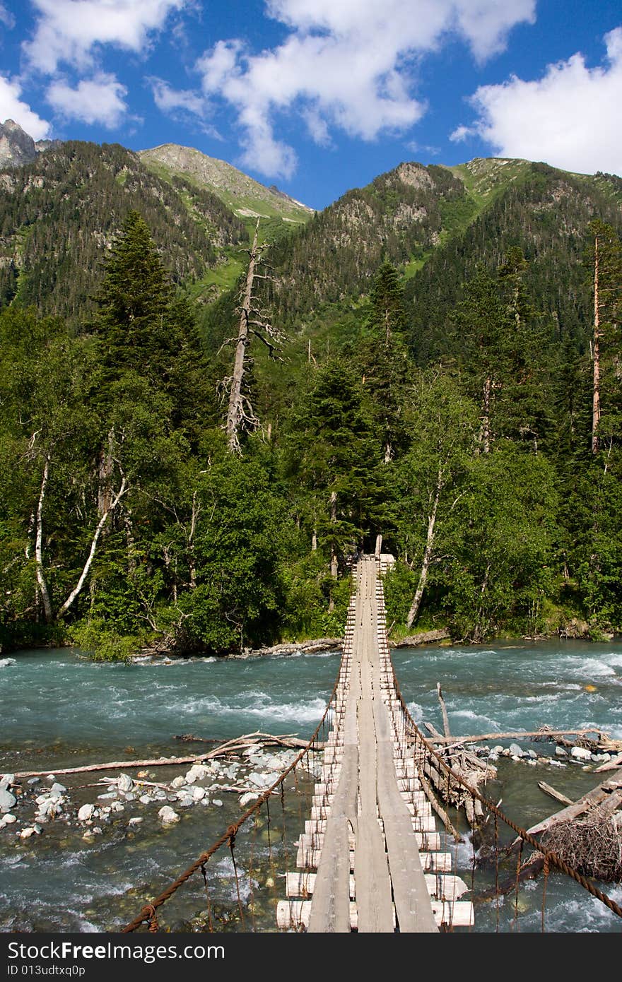 Wooden foot-bridge over mountain river. Wooden foot-bridge over mountain river