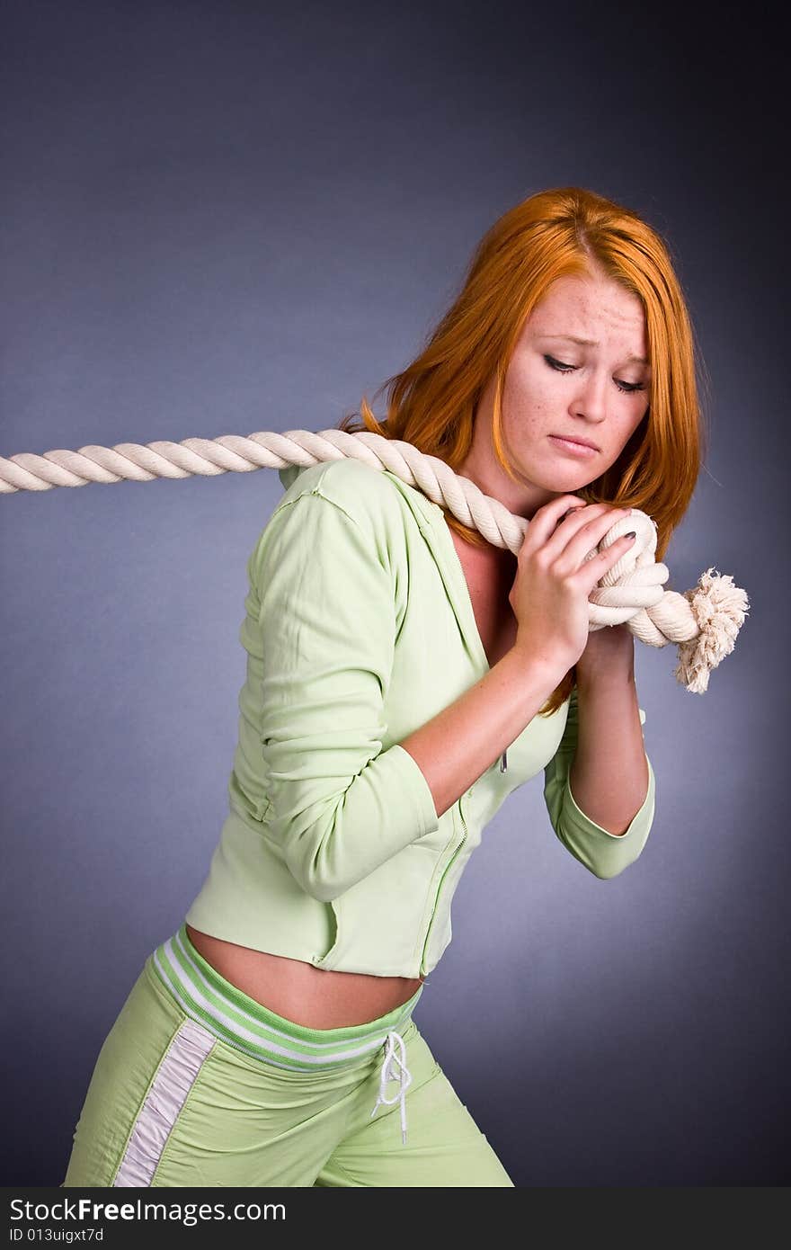 The young woman in a sports suit pulls a rope