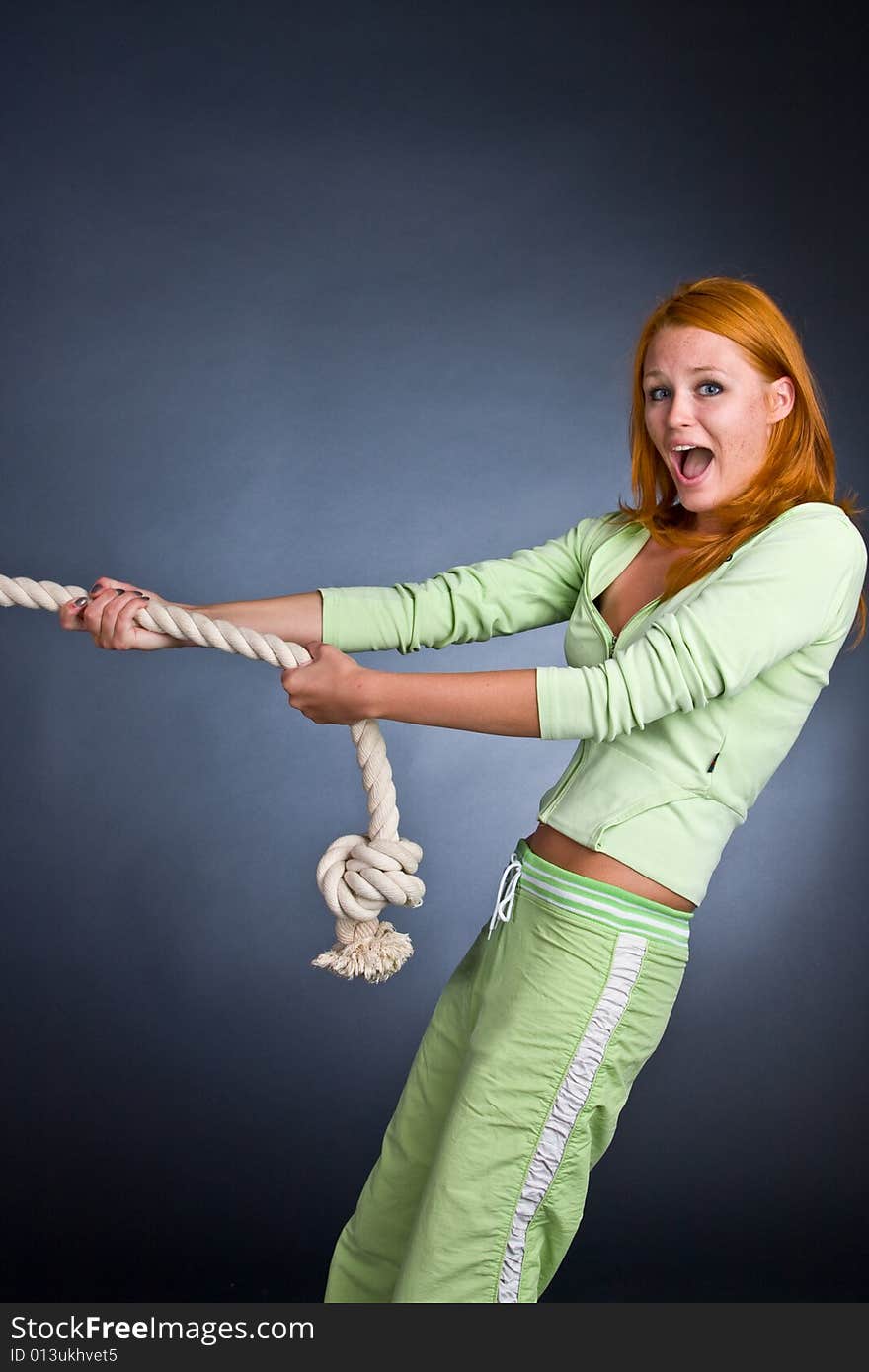 The Young Woman In A Sports Suit Pulls A Rope