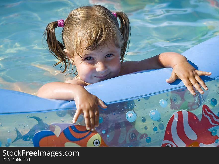 Nice little girl is smiling in the pool. Nice little girl is smiling in the pool.