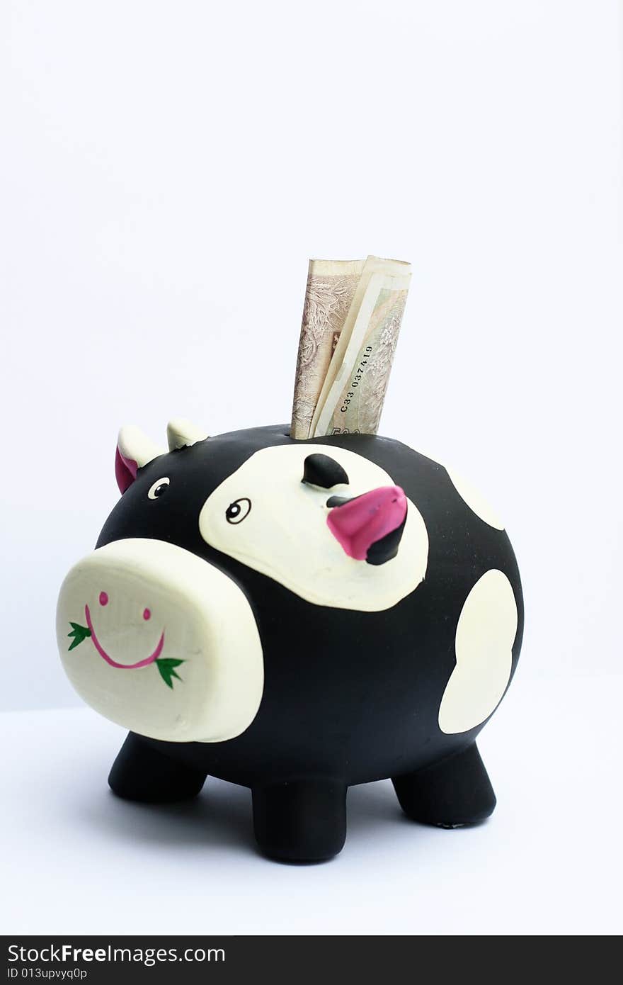 The Czech money sticks out of a cow bank. The Czech money sticks out of a cow bank.