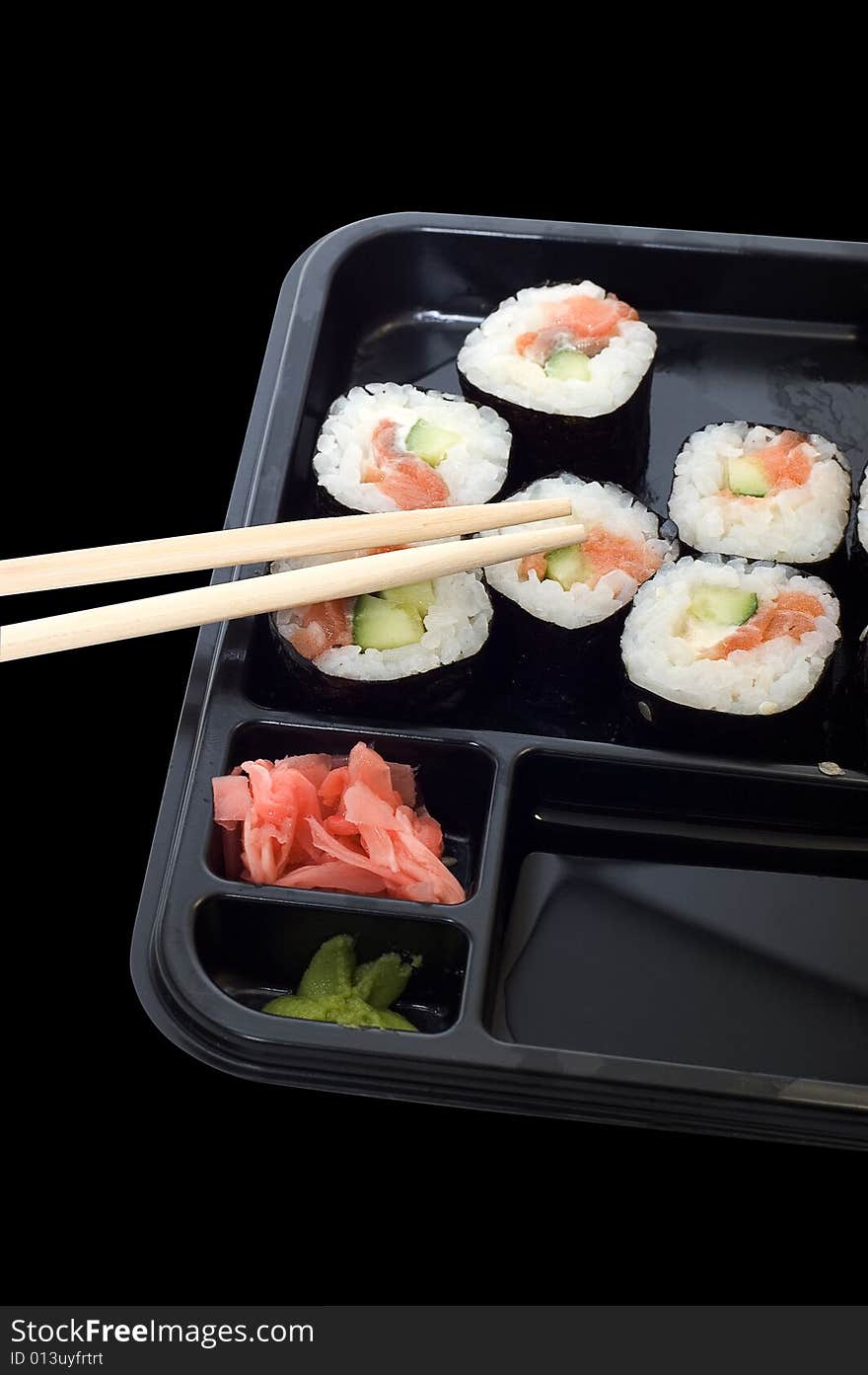 Rolls of sushi on a plate with chopsticks.