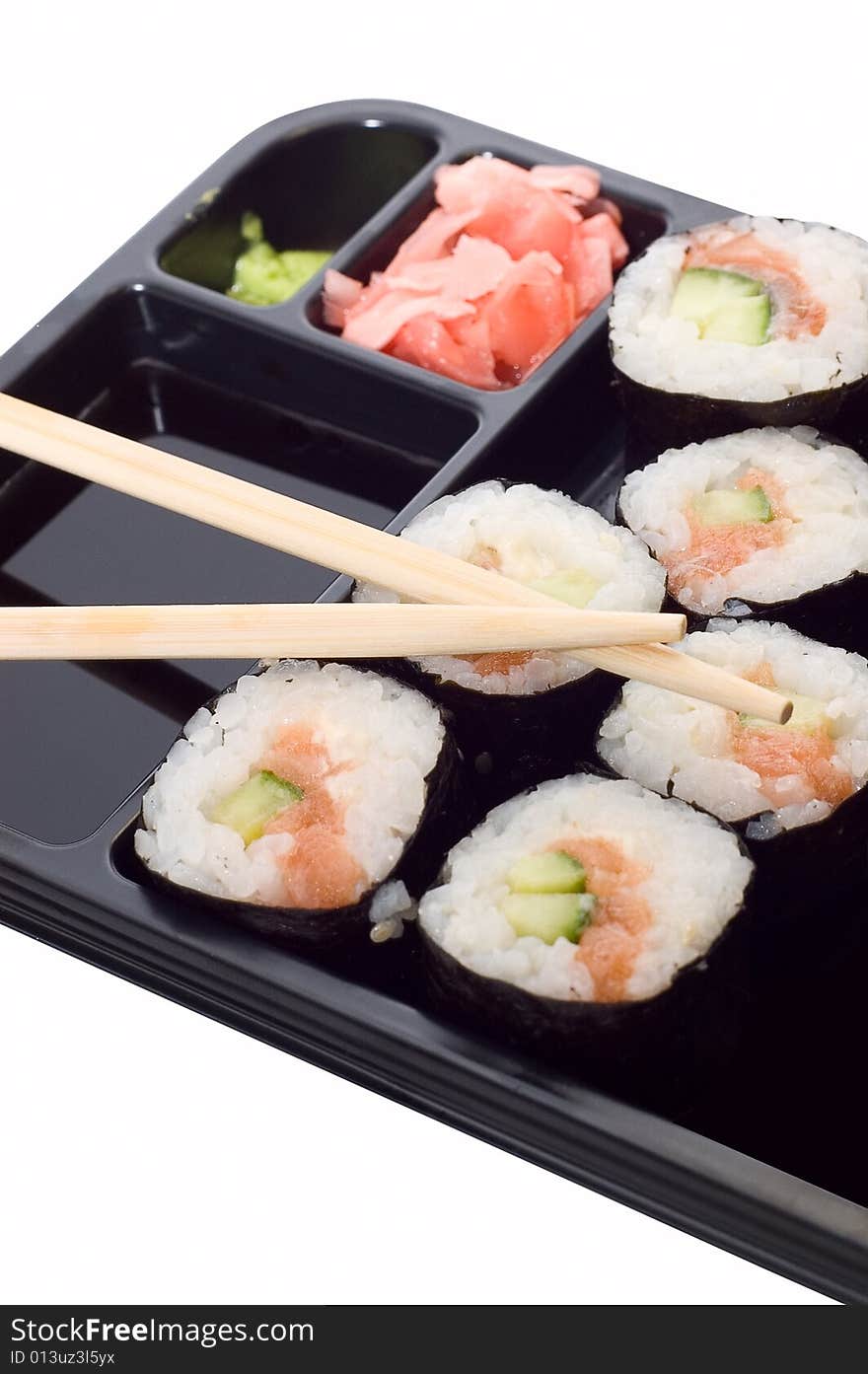 Rolls of sushi on a plate with chopsticks.